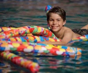 Boy with pool noodles