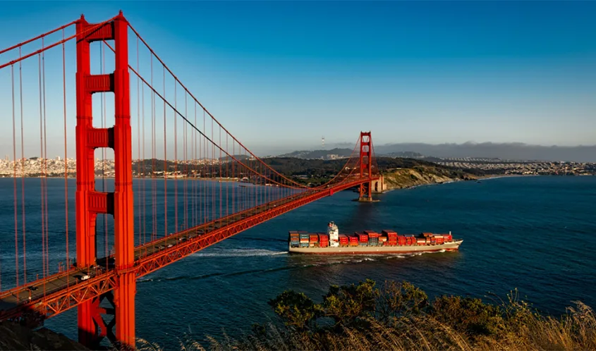 A container ship passes beneath the Golden Gate Bridge